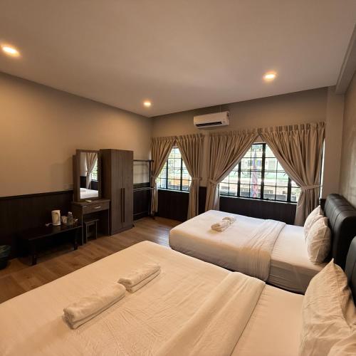 a hotel room with two beds and a television at Concrete Jungle Cabin in Kota Kinabalu