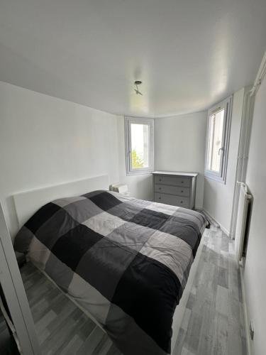 a bedroom with a black and white bed in it at Très beau logement chic & cosy in Bonneuil-sur-Marne