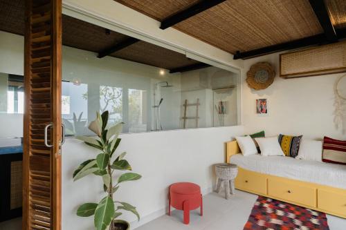 ein Schlafzimmer mit einem Bett und einem roten Hocker in der Unterkunft Mar de Uluwatu - Ocean View Villa in Uluwatu