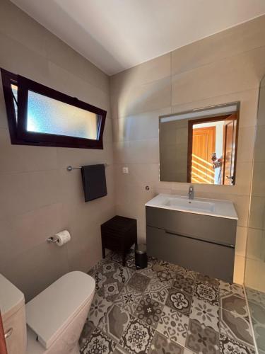 a bathroom with a toilet and a sink and a mirror at Casa Mía in Corralejo