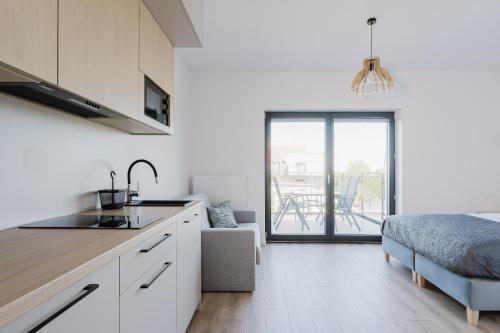 cocina y sala de estar con cama y mesa en S1 Apartamenty, en Rewa