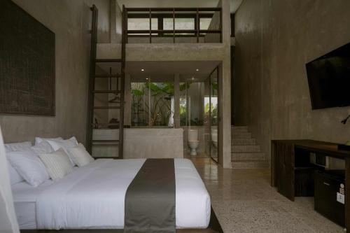 een slaapkamer met een groot bed en een televisie bij Tibah in Tanah Lot