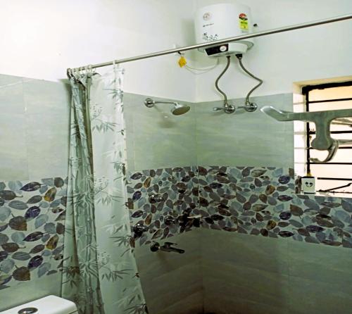 サンティ・ニケタンにあるARANYAK Homestayのシャワーカーテン付きのシャワー付きバスルーム
