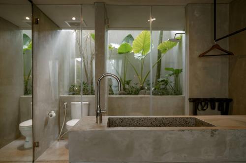 een badkamer met een wastafel en een toilet bij Tibah in Tanah Lot