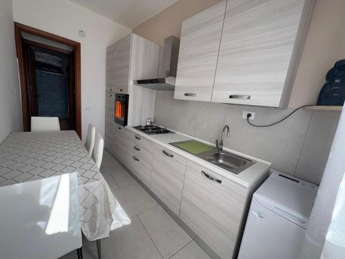 une petite cuisine avec un évier et une table dans l'établissement Casa Karmel, à Campofelice di Roccella