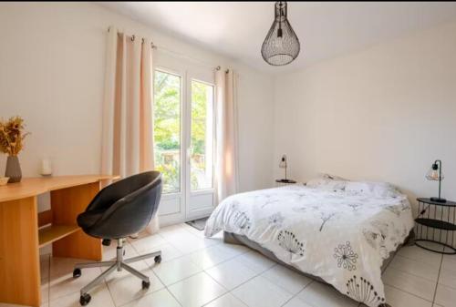 ein Schlafzimmer mit einem Bett, einem Schreibtisch und einem Stuhl in der Unterkunft logement indépendant avec jardinet in Bouc-Bel-Air