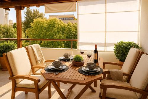 a wooden table with a bottle of wine and chairs at Belvedere Luxury Suite in Tríkala