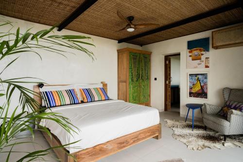 ein Schlafzimmer mit einem Bett und einer Topfpflanze in der Unterkunft Mar de Uluwatu - Ocean View Villa in Uluwatu