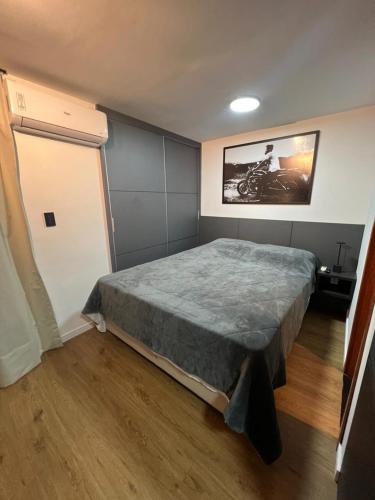 a bedroom with a bed and a painting on the wall at Studio Moderno com automação e vista incrível in Juiz de Fora