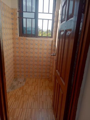 een badkamer met een douche met een glazen deur bij Chambre et Salon in Agboogba