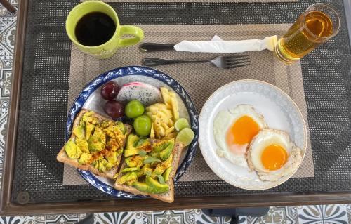 a tray with a breakfast plate of eggs and toast at La Petite Maison Luang Prabang in Luang Prabang