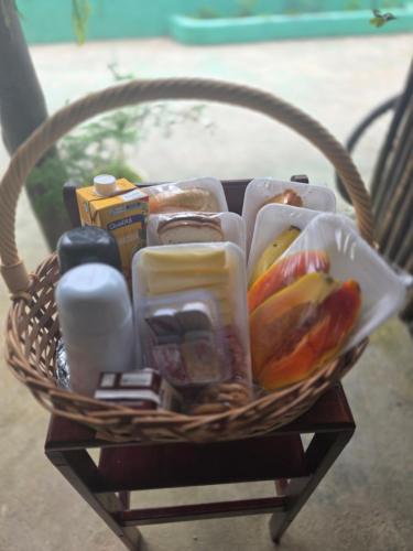 a basket filled with food and other items on a chair at Suítes Ohana in Peruíbe