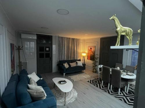 a living room with a blue couch and a giraffe statue at JUCIN apartman in Zrenjanin