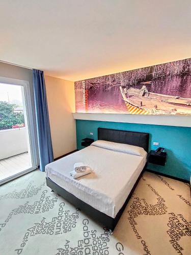 a bedroom with a bed and a painting on the wall at Ristorante Locanda 7 Mari in Porto Viro