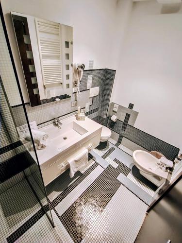 a bathroom with a sink and a toilet and a mirror at Ristorante Locanda 7 Mari in Porto Viro