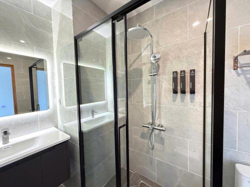 une salle de bain avec douche et lavabo dans l'établissement Amarin Resort & Spa Phu Quoc, à Duong Dong