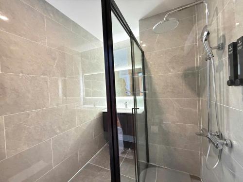 une douche avec une porte vitrée dans une salle de bain dans l'établissement Amarin Resort & Spa Phu Quoc, à Duong Dong