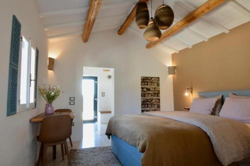 a bedroom with a large bed and a table at Tramontana Casetta in Castilenti