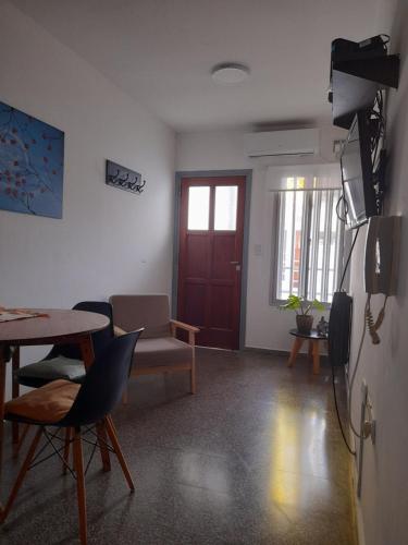 ein Wohnzimmer mit einem Tisch und einem Kühlschrank in der Unterkunft La Estrella - alojamiento temporario in La Plata