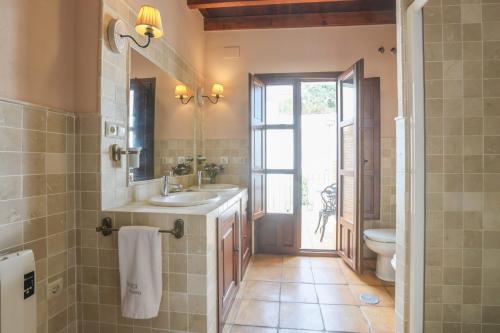 Un baño con lavabo, inodoro y espejo. en Andalucia, Aracena, en Aracena