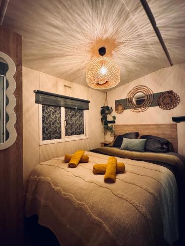 a bedroom with a bed with two yellow pillows on it at Tante Truus - Gezellig huisje op kindvriendelijk vakantiepark met zwembad in Hoenderloo