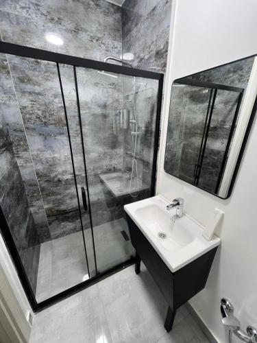 a bathroom with a glass shower and a sink at Marison Hotel Baku in Baku