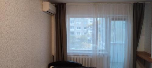 um quarto com uma janela com uma cortina e uma janela em CheapStayVilnius em Vilnius