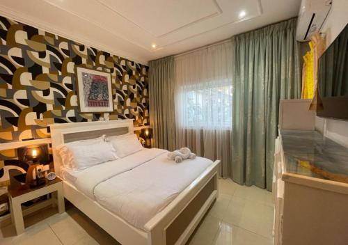 a bedroom with a bed and a large window at Retreat Cameroon BASTOS in Yaoundé