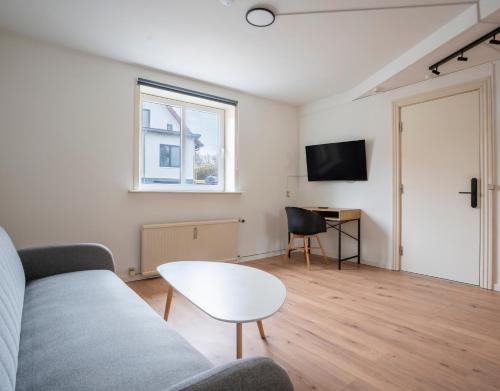 a living room with a couch and a table at City Apartments in Holstebro