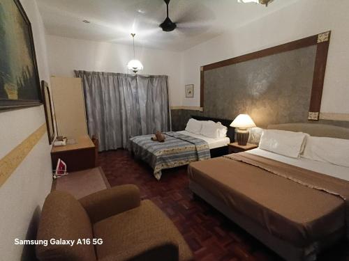 ein Hotelzimmer mit zwei Betten und einer Couch in der Unterkunft Selesa Hillhomes bukit Tinggi Pahang in Bentong