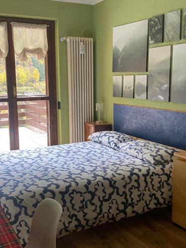 a bedroom with a blue and white bed and a window at Il Sole di Ester in Branzi