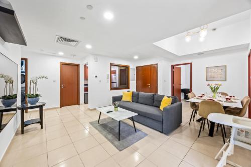 a living room with a couch and a table at Prime Spacious 5 Plus 1 BR Apt On JBR Beach near Metro ,Walk to The Mall, Dining & Entertainment - By Sunkissed Holiday Homes in Dubai