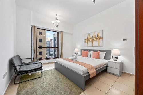 a bedroom with a bed and a chair and a window at Prime Spacious 5 Plus 1 BR Apt On JBR Beach near Metro ,Walk to The Mall, Dining & Entertainment - By Sunkissed Holiday Homes in Dubai