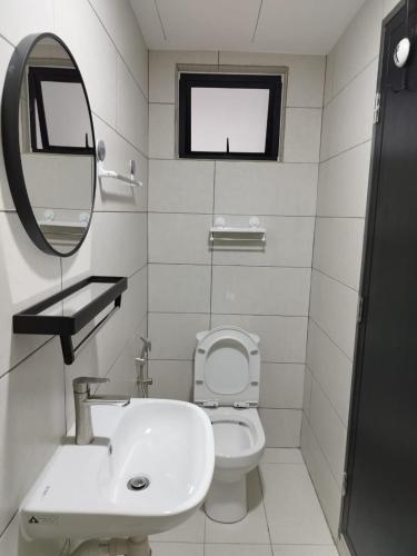 a bathroom with a sink and a toilet and a mirror at Studio Unit Marc Residence in Bukit Mertajam