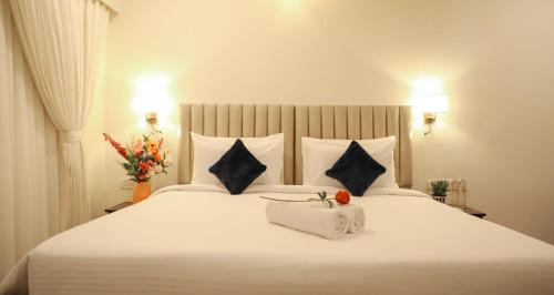a bedroom with a large white bed with two pillows at Ello Hotels in Bengaluru