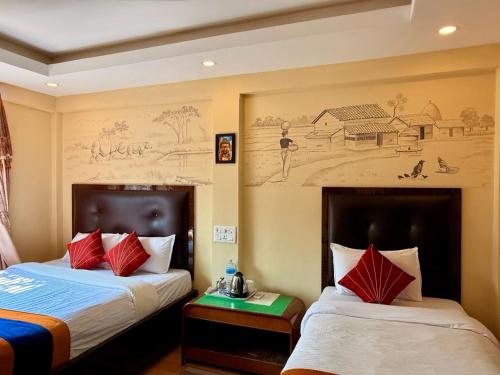 a hotel room with two beds and a painting on the wall at Travellers Jungle Camp-Sauraha in Sauraha