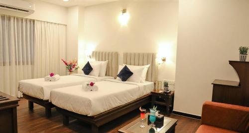 um quarto de hotel com duas camas com flores em Ello Hotels em Bangalore