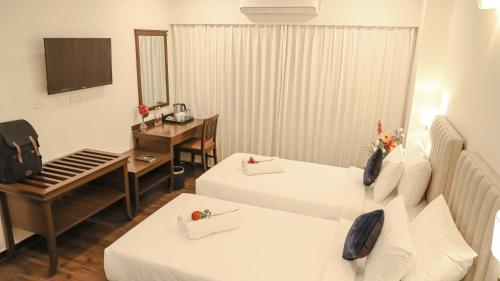 a hotel room with two beds and a piano at Ello Hotels in Bengaluru