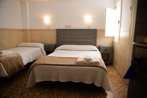 two beds in a room with towels on them at Pensión Juan Pedro in Roquetas de Mar