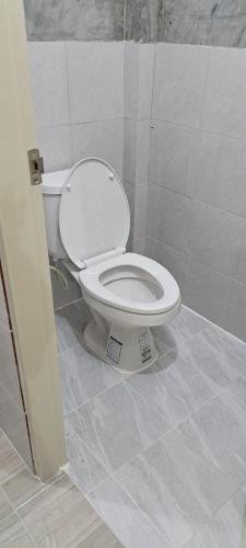 a bathroom with a white toilet in a stall at Yao Noi Hostel by KR in Ko Yao Noi