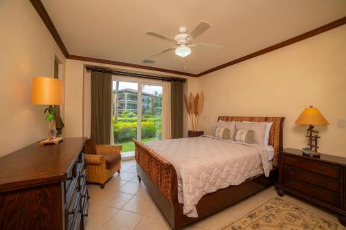 a bedroom with a bed and a dresser and a window at Bay Residence 9F 3 bdr Garden View in Los Suenos in Jacó