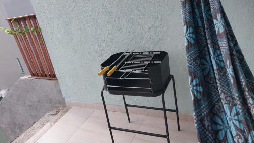 a grill sitting on a stool next to a wall at Alzira casa completa Iguaba in Iguaba Grande