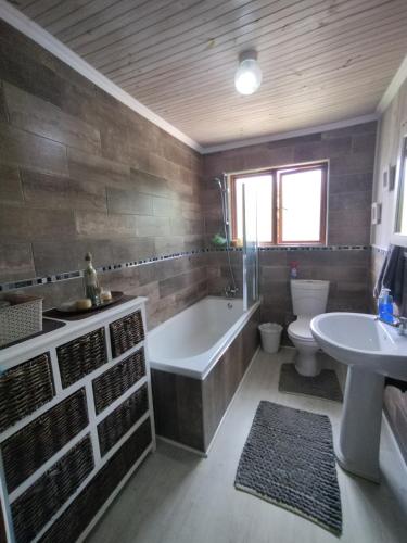 Un baño con bañera, inodoro y lavabo. en Zen-Vibes Holiday Home, en George