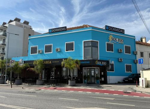 a blue building on the side of a street at Sol Rio De Alverca in Quinta da Verdelha
