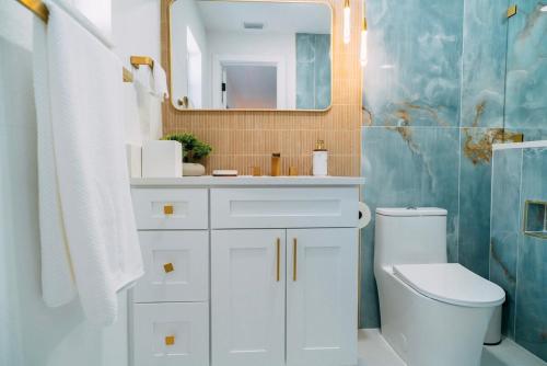 een badkamer met een wastafel, een toilet en een spiegel bij Hidden Haven in St Petersburg