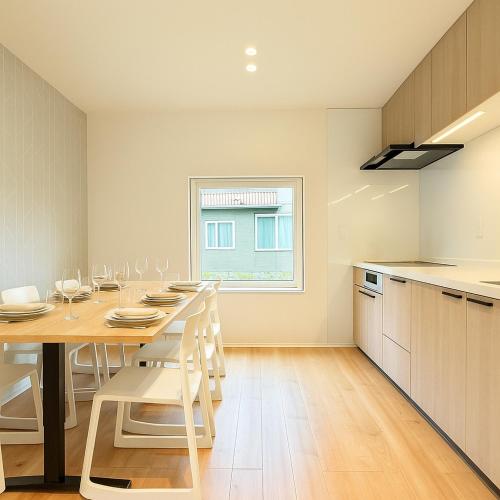 a kitchen with a wooden table and white chairs at The Lobs Toya, Chalet Secca in Lake Toya