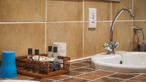 a bathroom with a sink and aaucet and a sink at Parkers Cottages in St Lucia