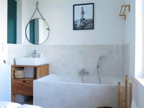 une salle de bains avec baignoire, lavabo et miroir dans l'établissement Christophe, à Le Touquet-Paris-Plage