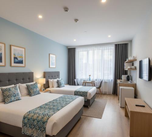 una habitación de hotel con dos camas y un sofá en Polen Apart, en Arsuz