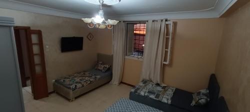 Maison Au bord de la mere في Mostaganem: غرفة معيشة مع أريكة ونافذة